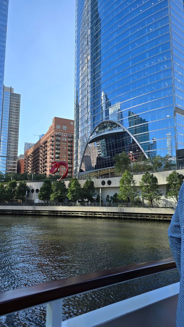 A large, glass building shot from a boat on the Chicago River