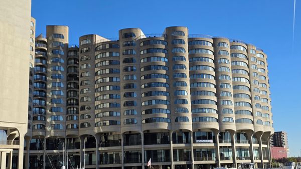 A rounded concrete building with many glass windows