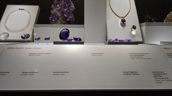 A display of several amethyst gemstones, some set in jewelry