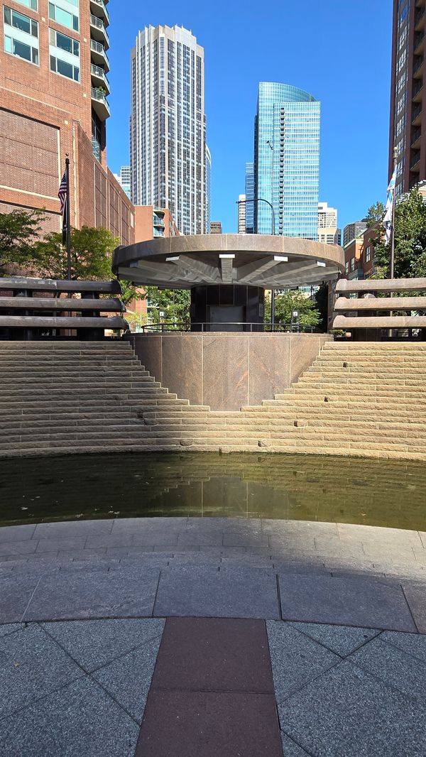 A concrete fountain with a large, circular centerpiece. The fountain is not on.