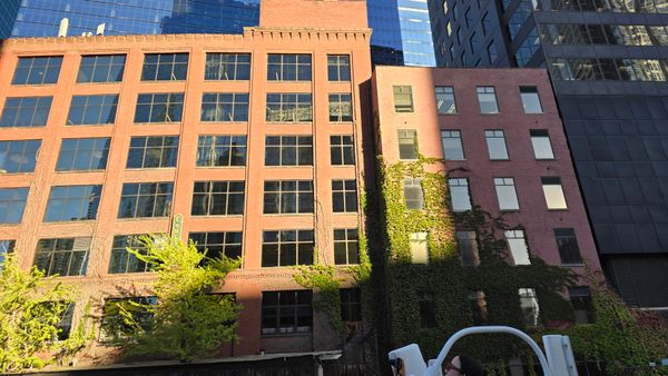 A brick building covered in ivy with large windows.